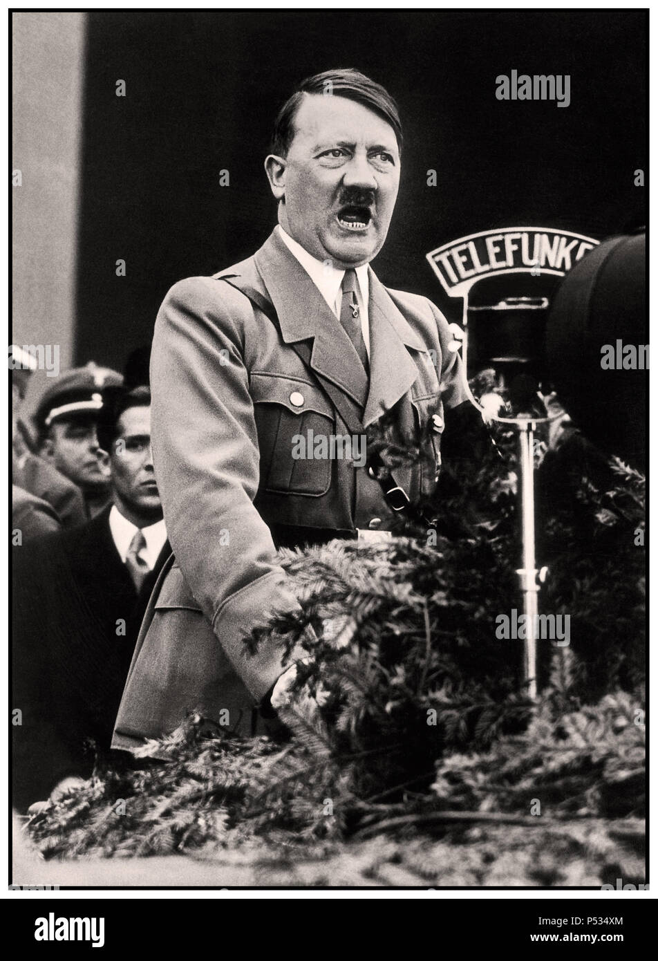 Discours d'Adolf Hitler de 1930, en uniforme militaire, avec Telefunken Radio microphone diffusant à la nation allemande debout sur le podium de la tribune de l'orateur lors d'un rassemblement du parti nazi à Nuremberg en Allemagne Banque D'Images