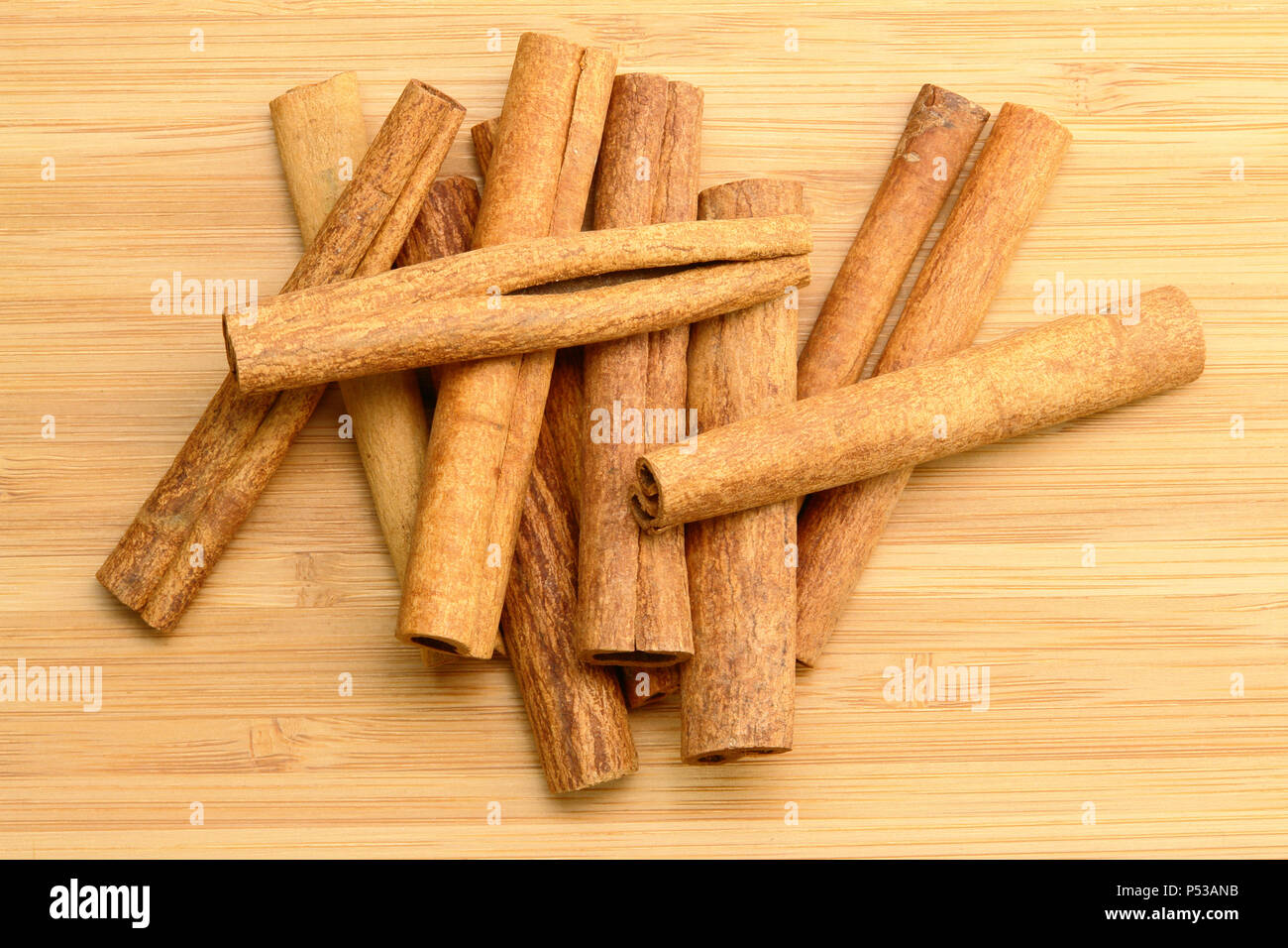 Pile de bâtons de cannelle (sur fond de bois) Banque D'Images