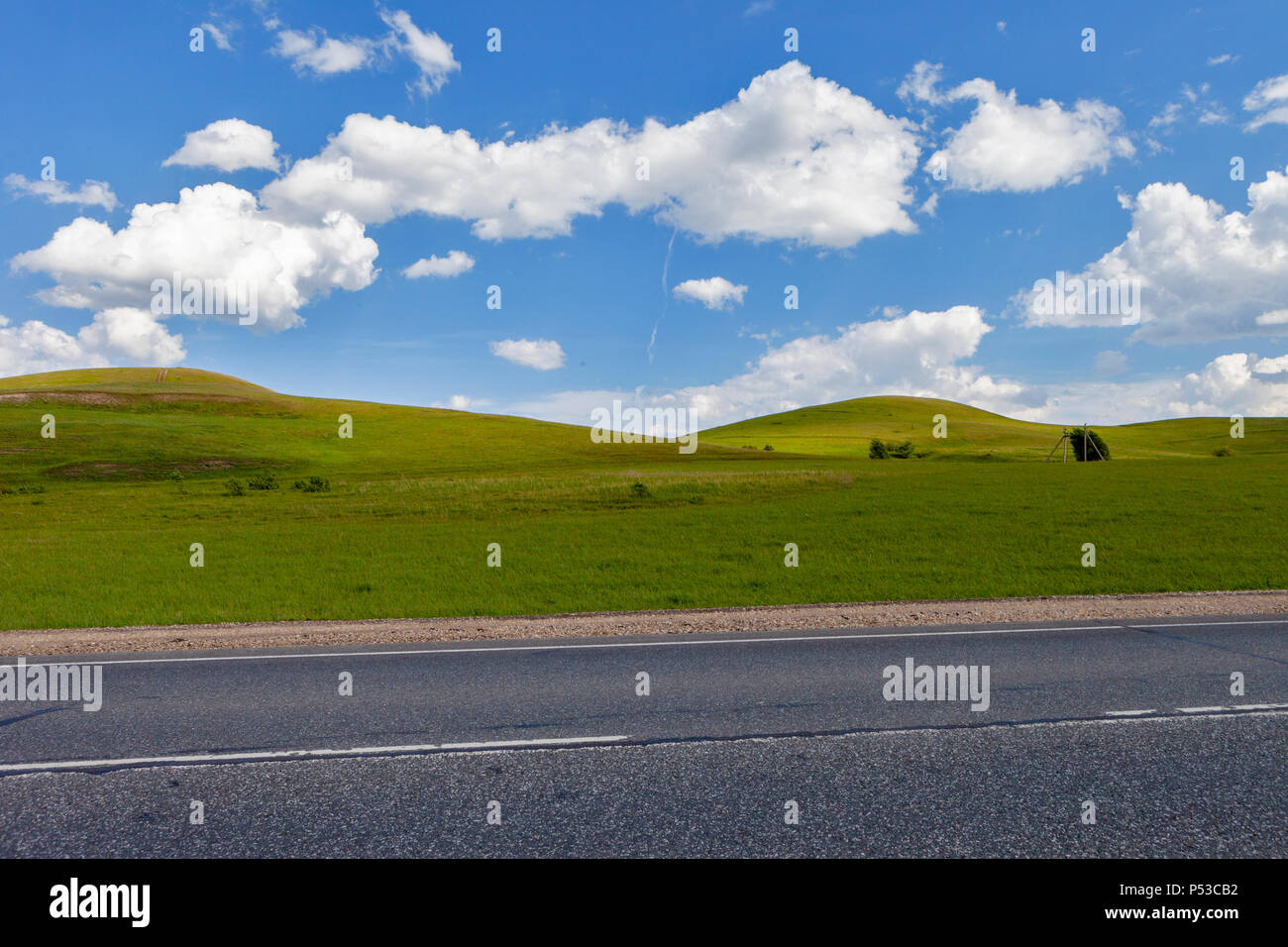 Dans le domaine routier, trail longue distance sur le terrain. De belles collines vertes. Ciel bleu avec des nuages. Banque D'Images