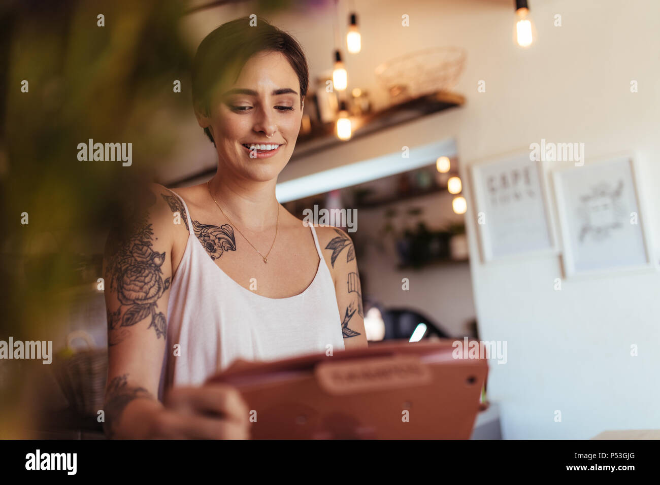 Femme debout au comptoir de facturation de son café à accepter des commandes. Gros plan d'une femme entrepreneur entrant dans l'ordre dans la machine de facturation. Banque D'Images