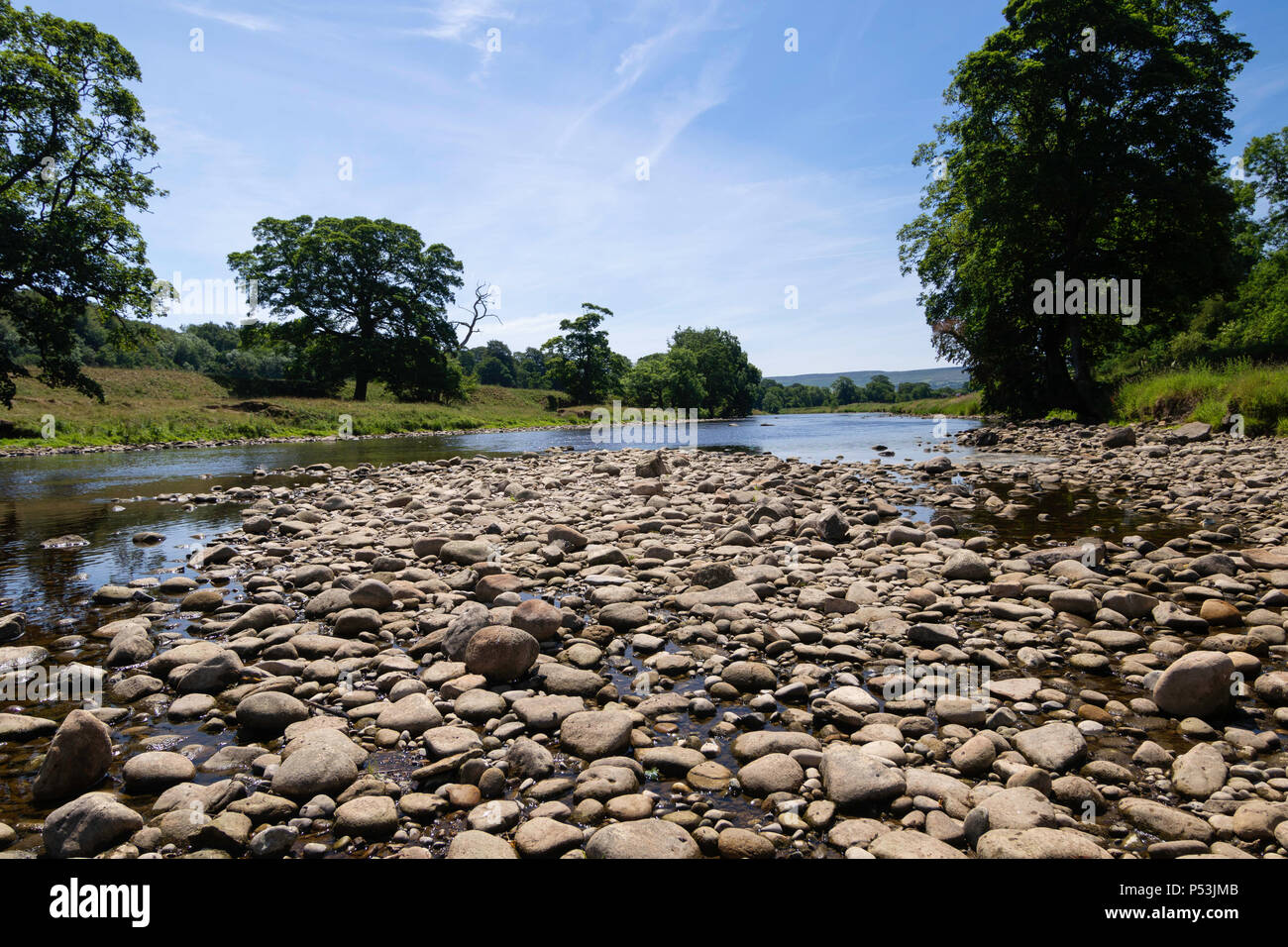 Une étendue de rochers et de pierres bordent les rives de la rivière Wharfe à Bolton Abbey Estate, Skipton, North Yorkshire, Angleterre, Royaume-Uni. Banque D'Images