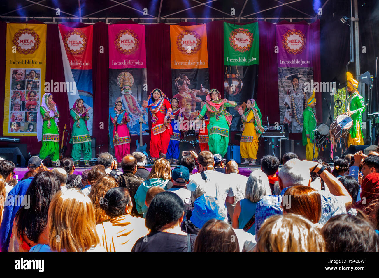 Un public à regarder les femmes de la Punjab Gabru de danseurs exécutant une danse Bhangra animée sur l'incroyable Inde scène à Glasgow Mela, 2018, Banque D'Images