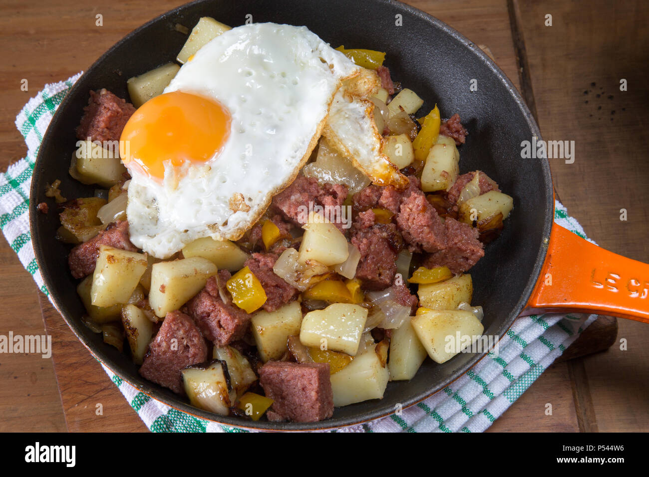 Corned beef hash fraîchement préparé avec un œuf frit servi dans la casserole. Banque D'Images