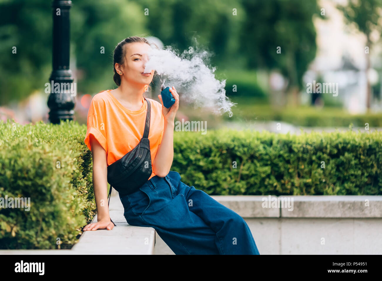 Jolie jeune fille vape portables populaires,gadget vaping device.Happy brunette fille vaper avec e-cig.Portrait de fumeur modèle féminin avec cigarett électronique Banque D'Images