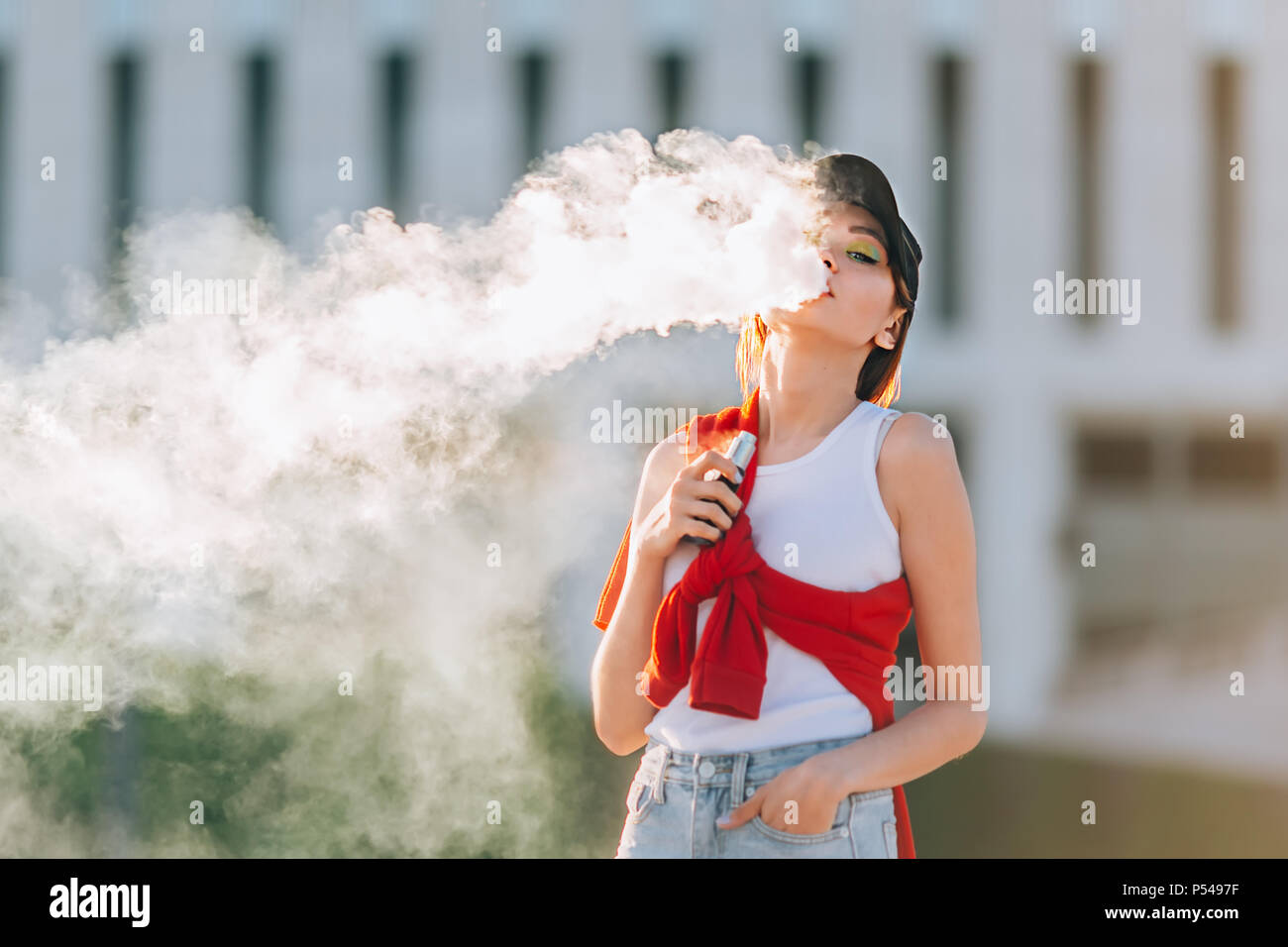 Jolie jeune fille asiatique vape portables populaires,gadget vaping device.Happy brunette fille vaper avec e-cig.Portrait de fumeur modèle féminin avec ec électronique Banque D'Images