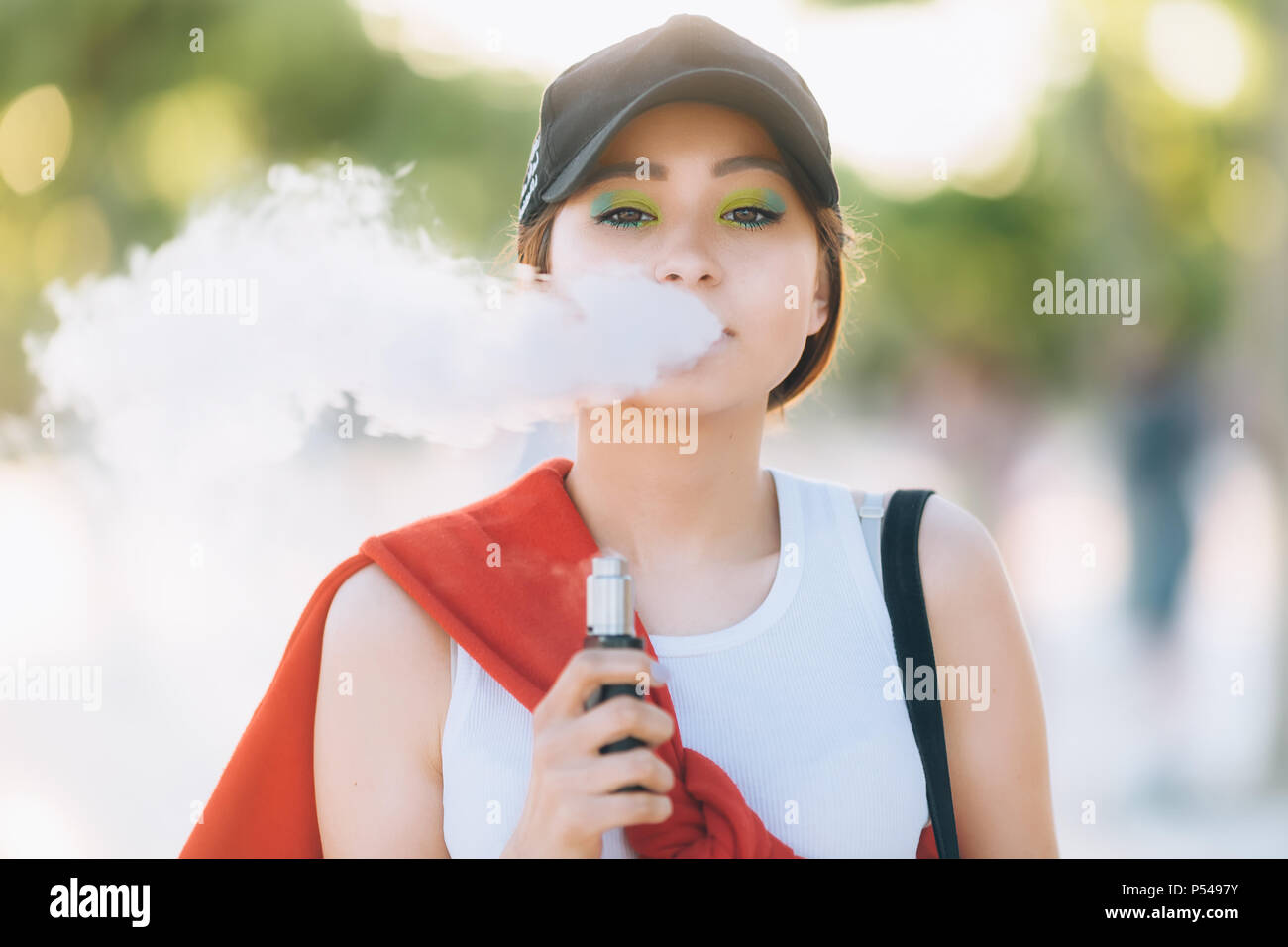 elfbar nachfüll pod läuft aus Jolie jeune fille asiatique vape portables populaires,gadget vaping  device.Happy brunette fille vaper avec e-cig.Portrait de fumeur modèle  féminin avec ec électronique Photo Stock