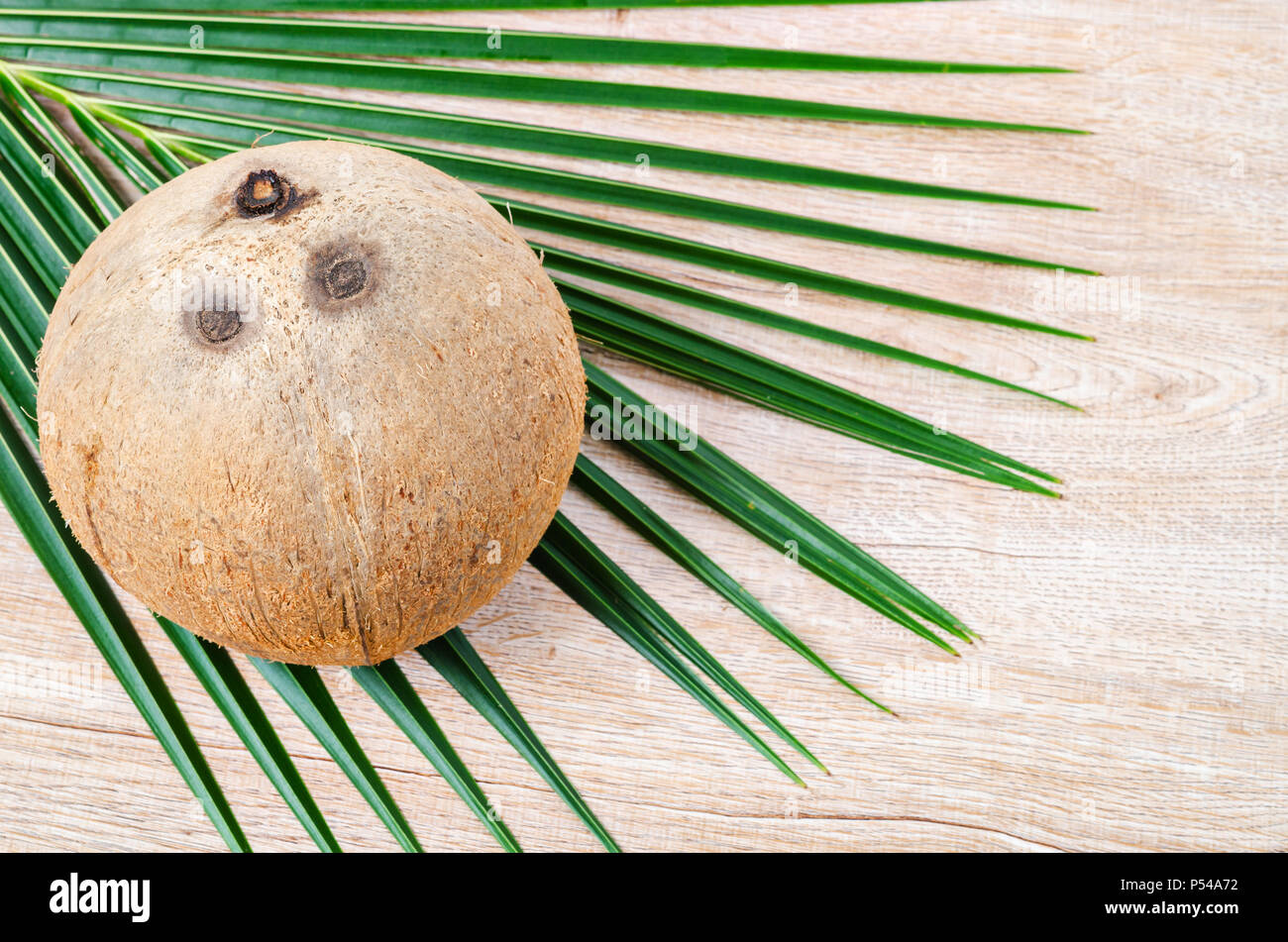 Avec la noix de coco noix de coco feuille verte sur fond de bois avec de l'espace libre pour votre texte ou message. Banque D'Images