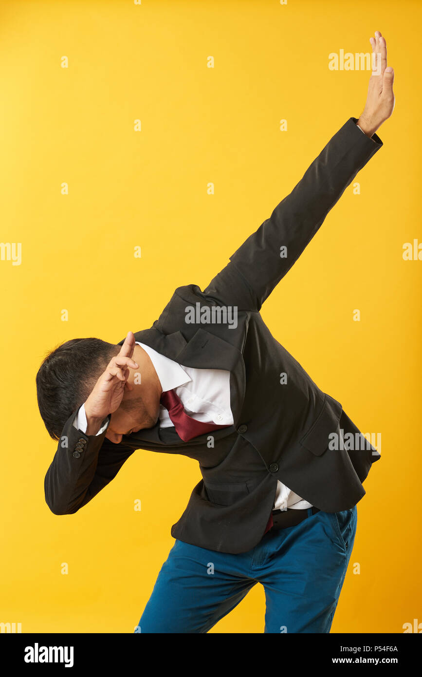 Young Asian man posture dab isolé sur fond jaune Banque D'Images