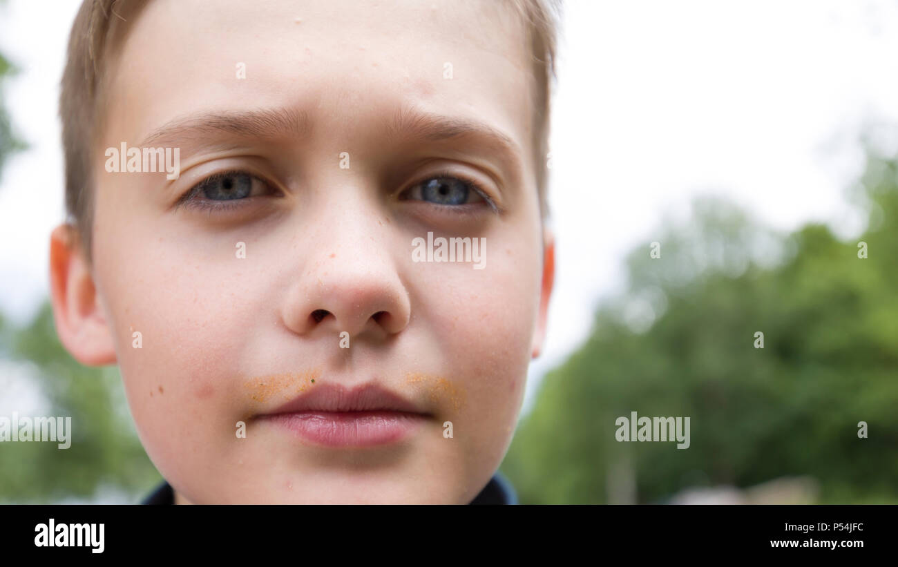 Extreme close up face portrait de blue eye 10 ans, jeune garçon à la recherche de sérieux et de confiance à l'appareil photo Banque D'Images