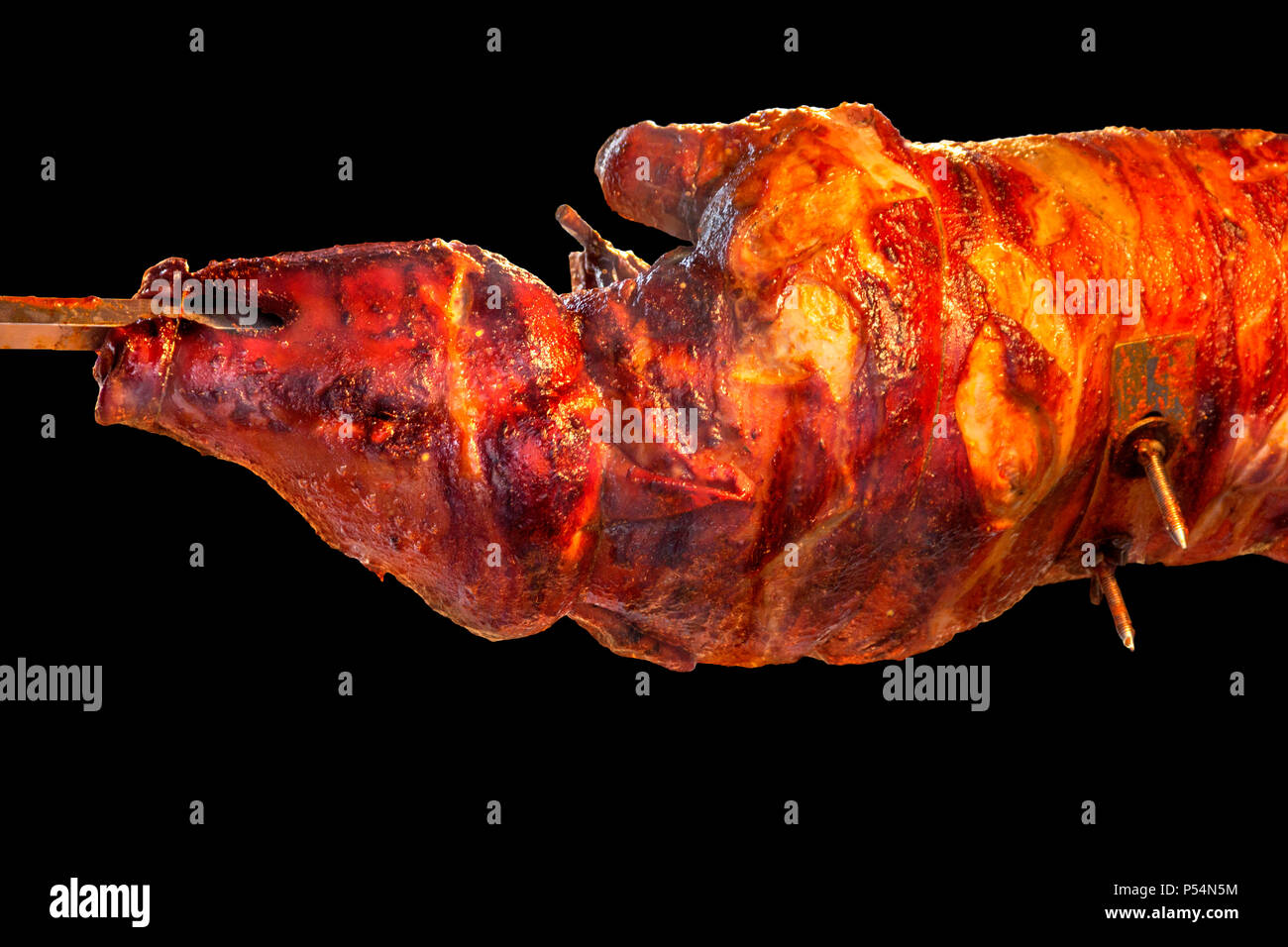 Barbecue de porc montrant un paysage de cochon de lait rôti à la broche  isolé en arrière noir Photo Stock - Alamy