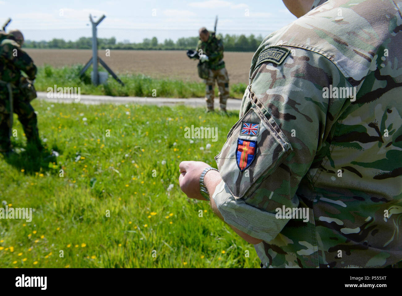 Un sous-officier de la sécurité européenne commune britannique de l'équipe de formation décrit comment nettoyer l'équipement de protection comme la confiance après l'Armée américaine à l'intérieur d'essai Centre de Support de formation Benelux de défense chimique, biologique, radiologique et nucléaire située sur la base aérienne de Chièvres, Belgique, le 09 mai 2017. Banque D'Images