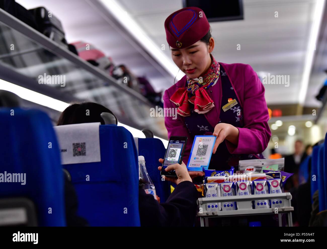 (180625) -- BEIJING, 25 juin 2018 (Xinhua) -- un passager paie pour l'eau en bouteille avec son téléphone portable dans un train du sud-ouest de la Chine Chongqing à Chengdu Le 9 février 2018. Pour la plupart des Chinois dans les années 1970, l'un de leurs rêves est de posséder trois choses à roues et d'un chose vocal" qui, à savoir, étaient une bicyclette, une machine à coudre, une montre et une radio. En gros, ce rêve est devenu facilement accessible pendant les années 1980 et les années 1990, et "les quatre grands" ont été remplacés par la télévision, réfrigérateur, lave-linge et magnétophone. Avec les besoins toujours croissants d'une vie meilleure avec eco rapide Banque D'Images