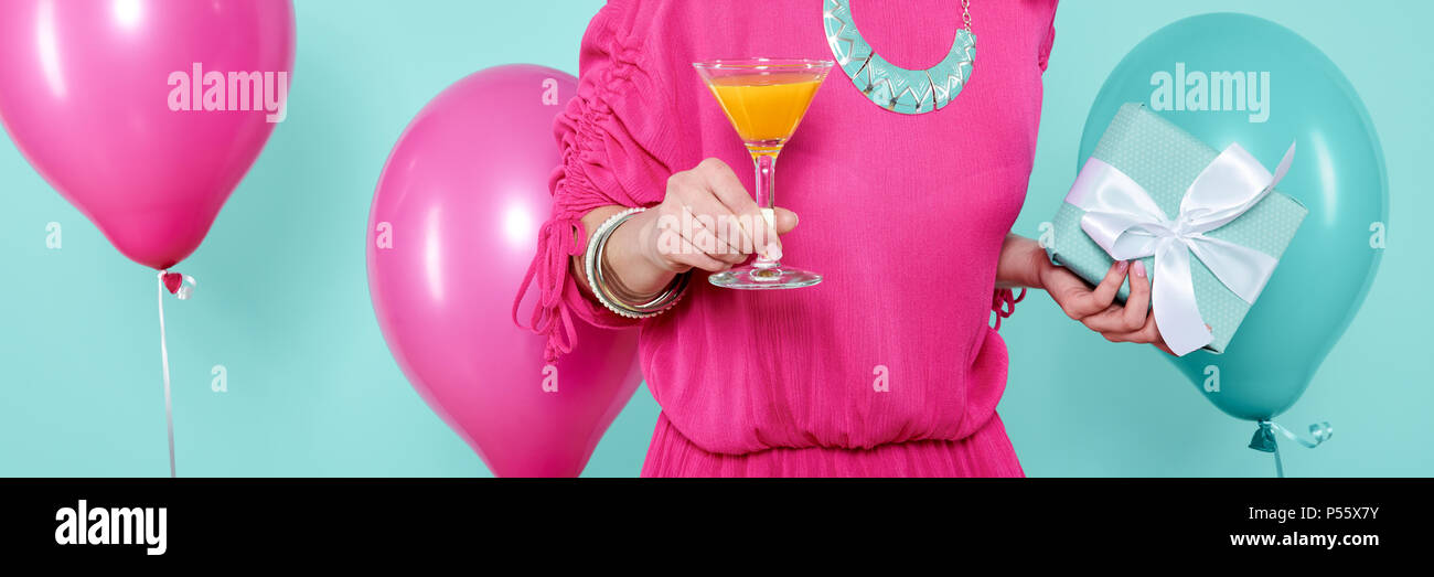 Superbe jeune femme dans party outfit tenue cadeau d'anniversaire et plus isolées, cocktail bleu pastel arrière-plan coloré. Bannière de fête d'anniversaire. Banque D'Images