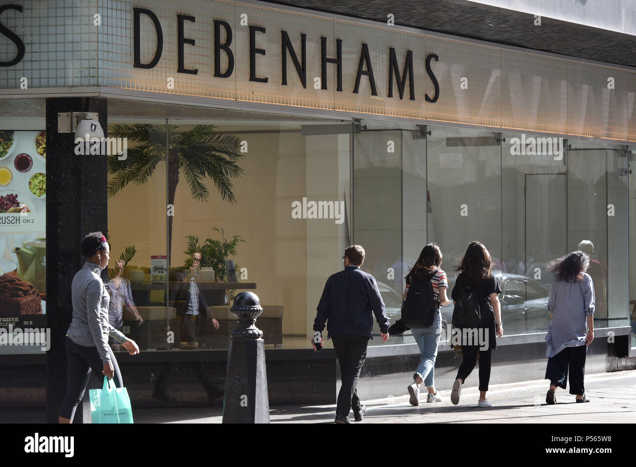 Consommateurs et aux touristes passent devant le grand magasin Debenhams sur Oxford Street, au centre de Londres. Banque D'Images