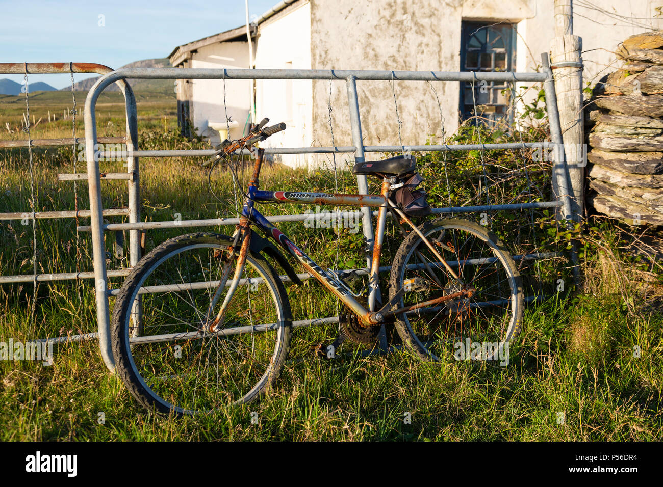 Vieux vélo rouillé calé contre une clôture, Valentia Island dans le comté de Kerry, Irlande Banque D'Images