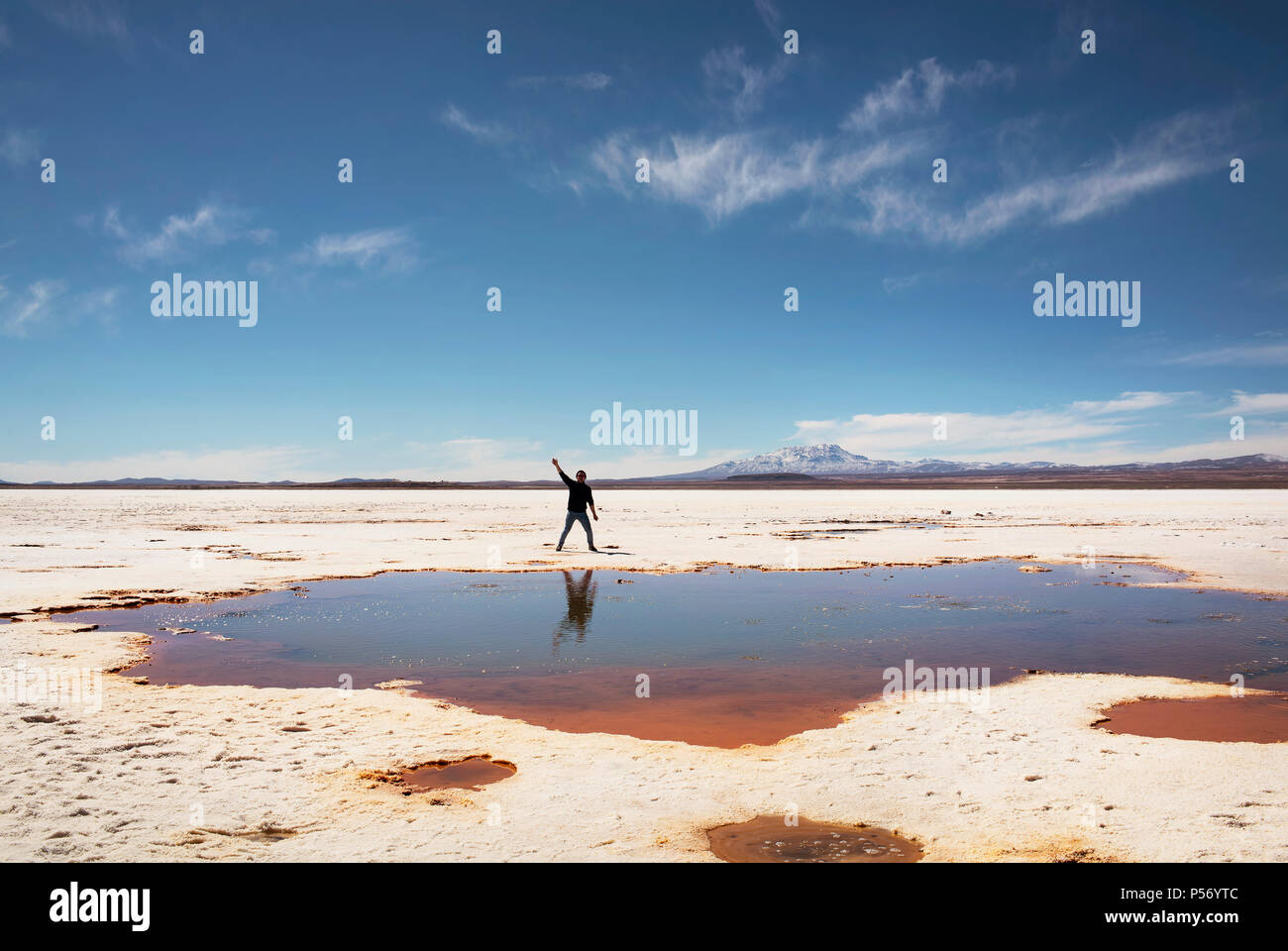 Acclamations sur le côté d'une flaque d'eau salée naturelle au Salar de Uyuni, Bolivie. Banque D'Images