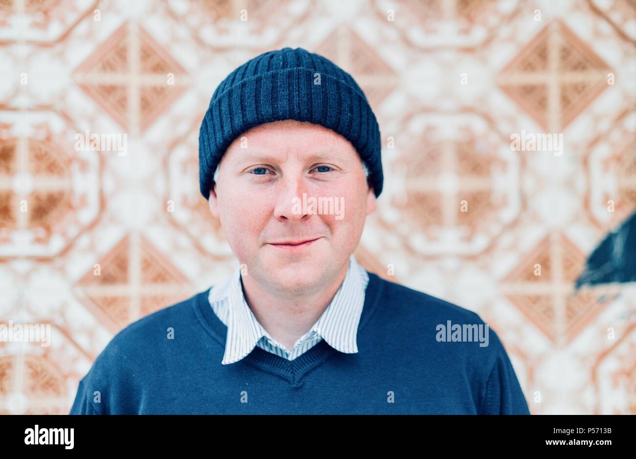 Un bel homme portant des vêtements urbains bleu marine et casquette de style hippie Banque D'Images