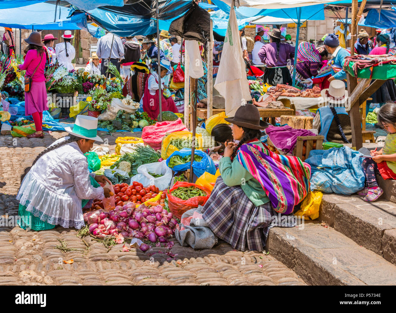 Marché de Pisac Pisac, Pérou, les femmes péruviennes en vêtements traditionnels colorés vendent des légumes locaux au marché sud-américain. Banque D'Images