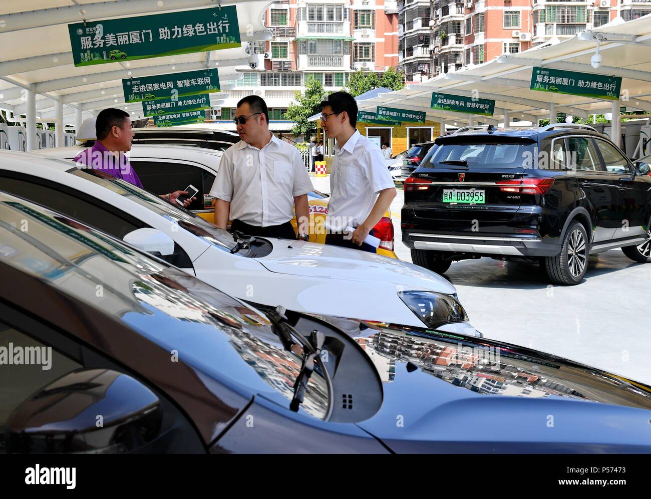 (180625) -- BEIJING, 25 juin 2018 (Xinhua) -- les gens attendent d'avoir leurs voitures électriques rechargées à Xiamen, dans le sud-est de la province de Fujian en Chine, le 25 mai 2018. Pour la plupart des Chinois dans les années 1970, l'un de leurs rêves est de posséder trois choses à roues et d'un chose vocal" qui, à savoir, étaient une bicyclette, une machine à coudre, une montre et une radio. En gros, ce rêve est devenu facilement accessible pendant les années 1980 et les années 1990, et "les quatre grands" ont été remplacés par la télévision, réfrigérateur, lave-linge et magnétophone. Avec les besoins toujours croissants d'une vie meilleure avec une croissance économique et technolog Banque D'Images