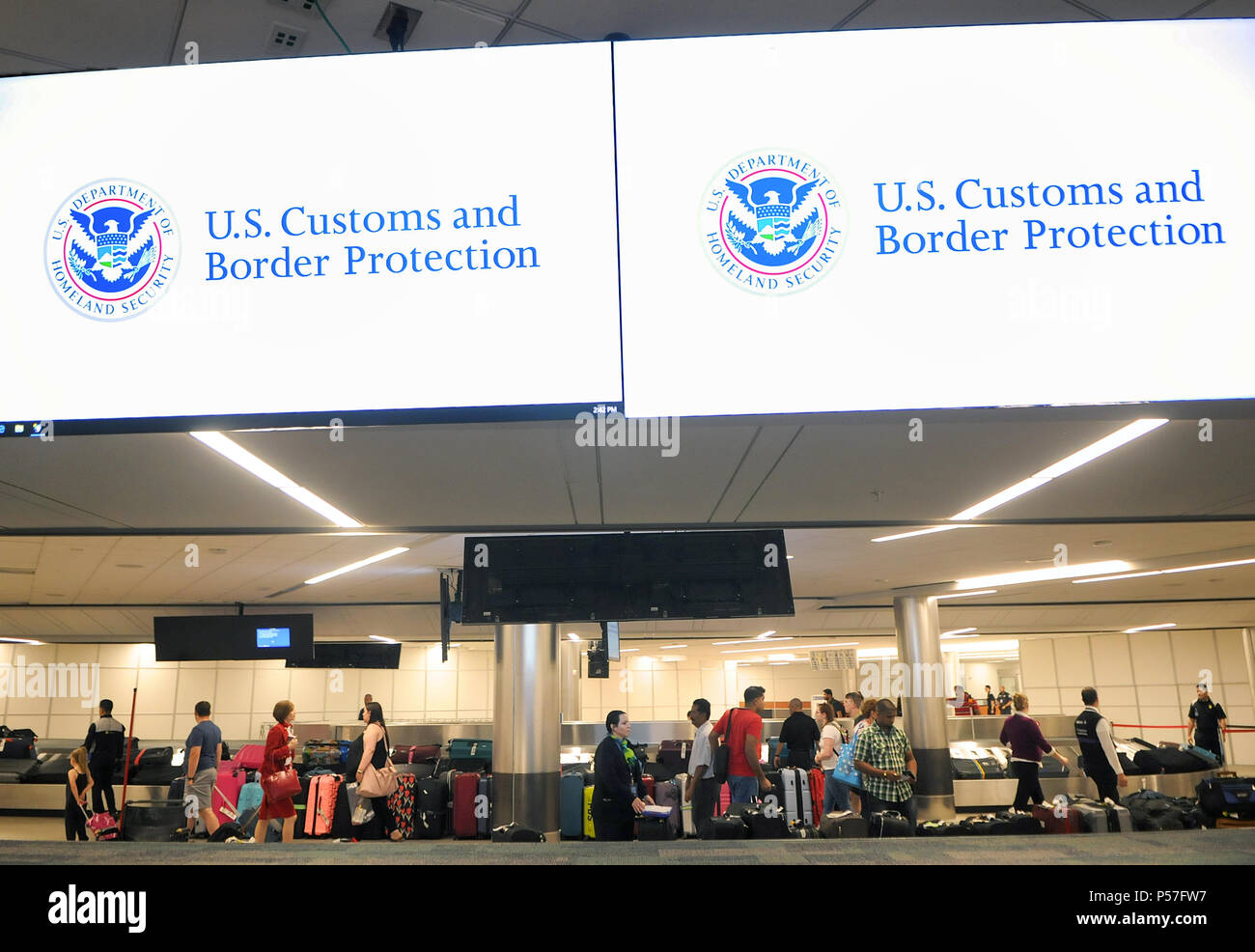 Orlando, Floride, USA. 25 Juin, 2018. Les voyageurs internationaux arrivant à l'Aéroport International d'Orlando à Orlando, Floride, récupérer leurs bagages du carrousel à bagages. Le service des douanes et de la protection des frontières à l'aéroport d'utiliser la technologie de reconnaissance faciale biométrique pour vérifier l'identité des voyageurs internationaux. Prendre une photo de policiers le voyageur à l'arrivée et à nouveau au départ. La photo est immédiatement associé à une galerie de photos historiques et d'autres de passeport du voyageur mis à jour par le gouvernement. Crédit : Paul Hennessy/Alamy Live News Banque D'Images