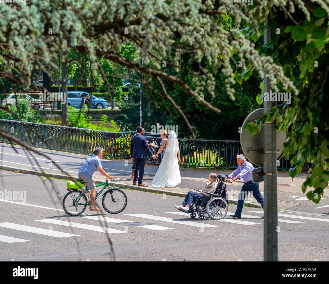 Strasbourg, mature man pushing woman in wheelchair, cycliste homme, passage pour piétons, de nouveaux mariés, photographe, rue, Alsace, Europe Banque D'Images