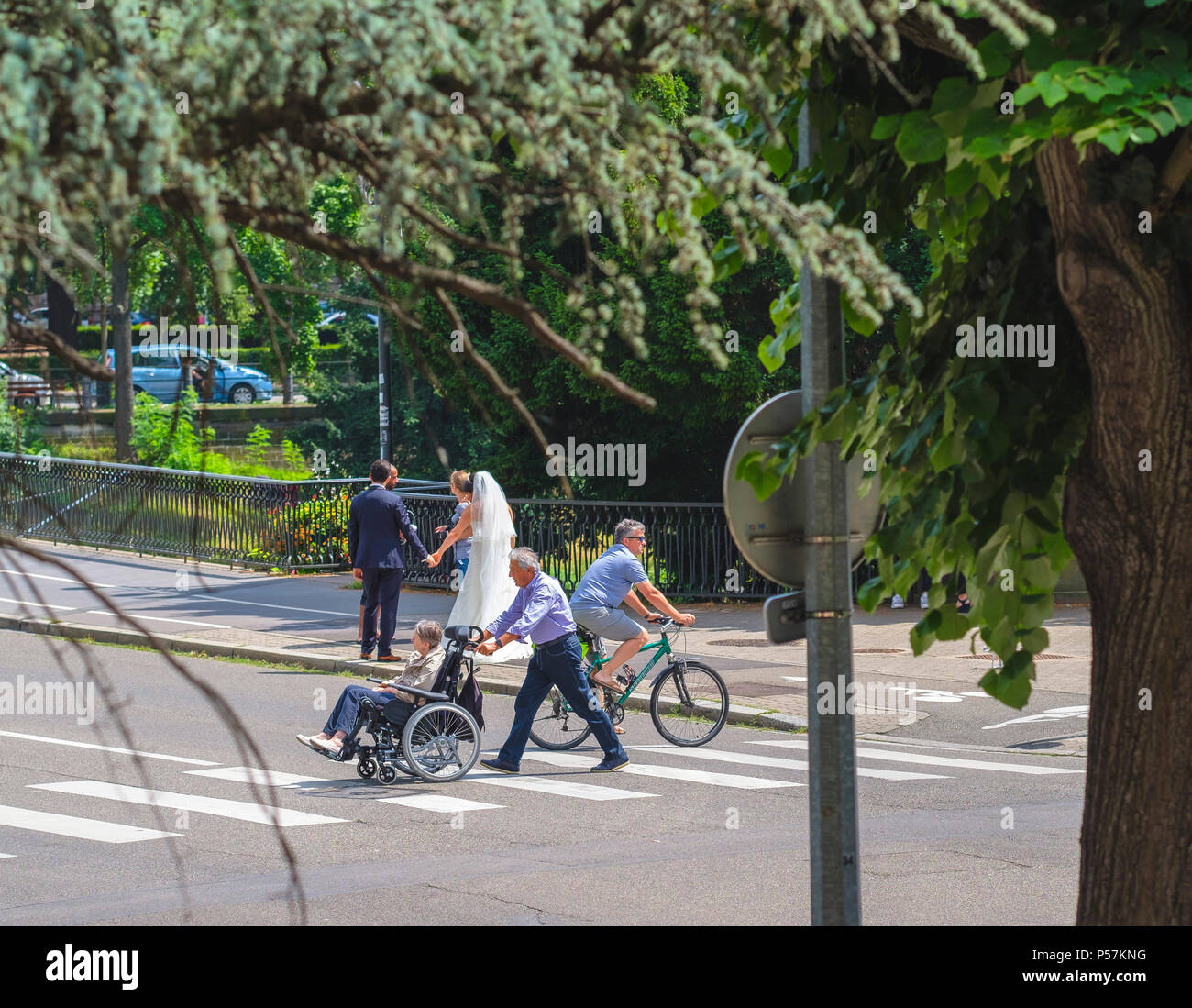 Strasbourg, mature man pushing woman in wheelchair, cycliste homme, passage pour piétons, de nouveaux mariés, photographe, rue, Alsace, Europe Banque D'Images