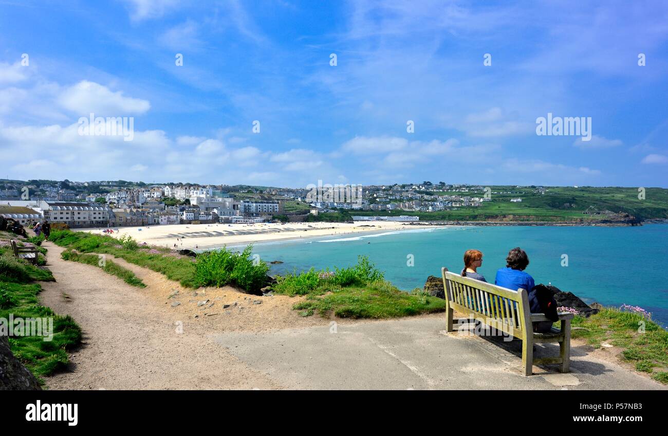 Couple assis sur un banc,en vue de Porthmeor beach, St Ives, Cornwall, England UK Banque D'Images