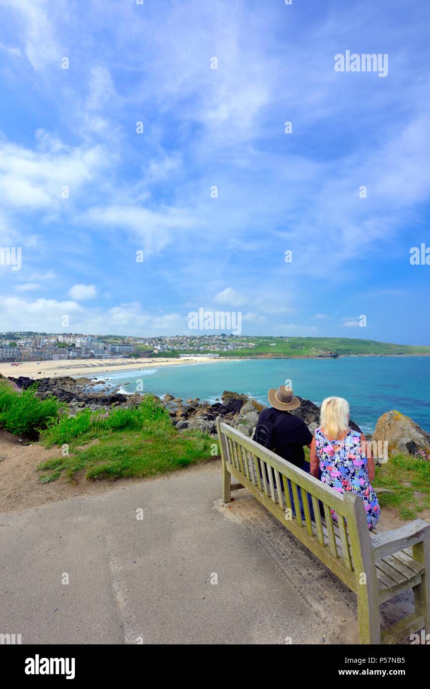 Couple assis sur un banc,en vue de Porthmeor beach, St Ives, Cornwall, England UK Banque D'Images
