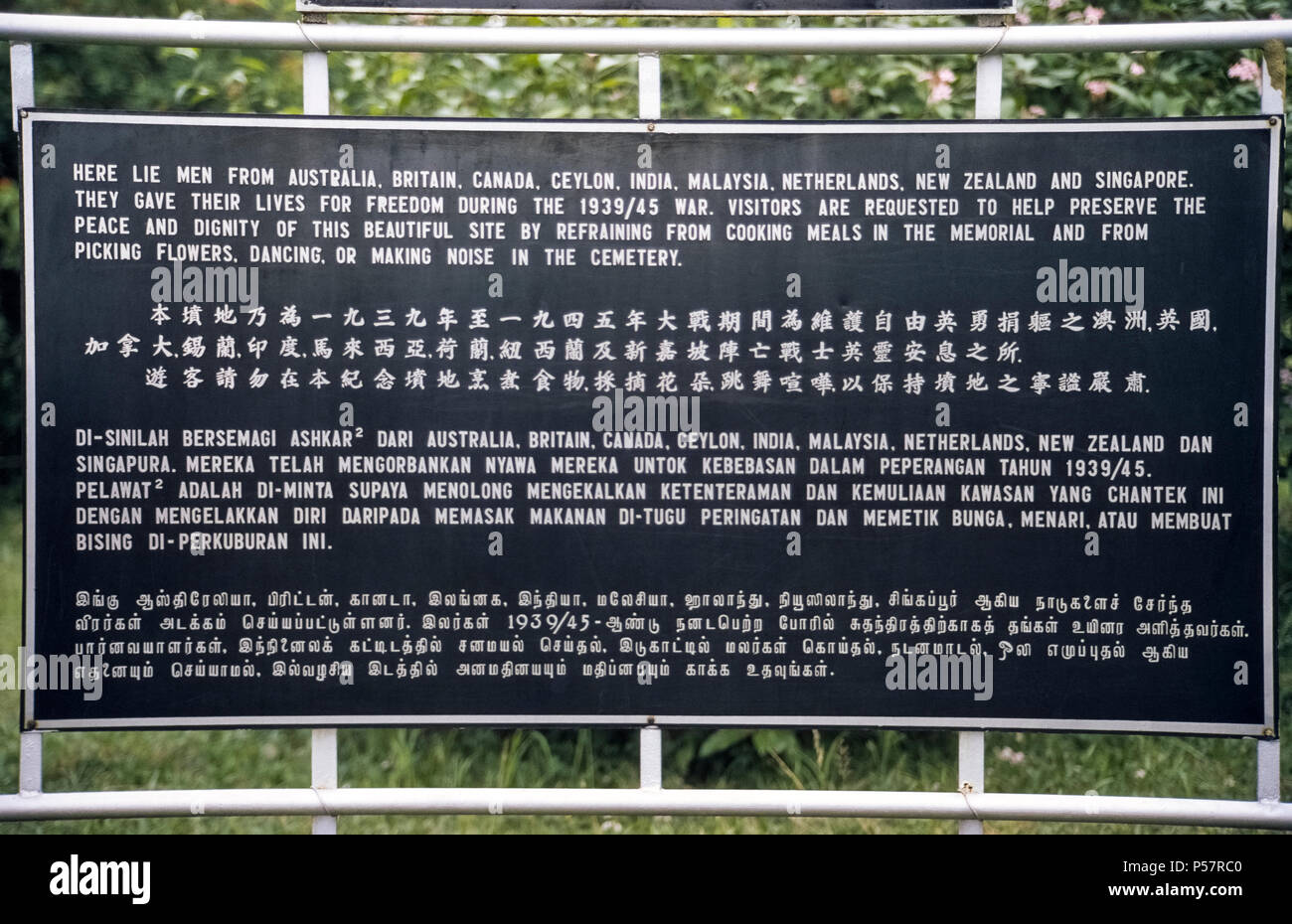 Un signe extérieur de façon inattendue en quatre langues visiteurs demande de ne pas faire cuire les repas, cueillir des fleurs, de la danse, ou faire du bruit dans le Kranji War Memorial, un cimetière hillside à Singapour qui honore les soldats de neuf nations qui ont donné leur vie dans l'exercice de leurs fonctions pendant la Seconde Guerre mondiale. Pierres tombales blanches marquer le reste de 4 461 hommes et femmes de l'Australie, la Grande-Bretagne, le Canada, de Ceylan (aujourd'hui Sri Lanka), l'Inde, Malaisie, Norvège, Nouvelle-Zélande et Singapour. Banque D'Images