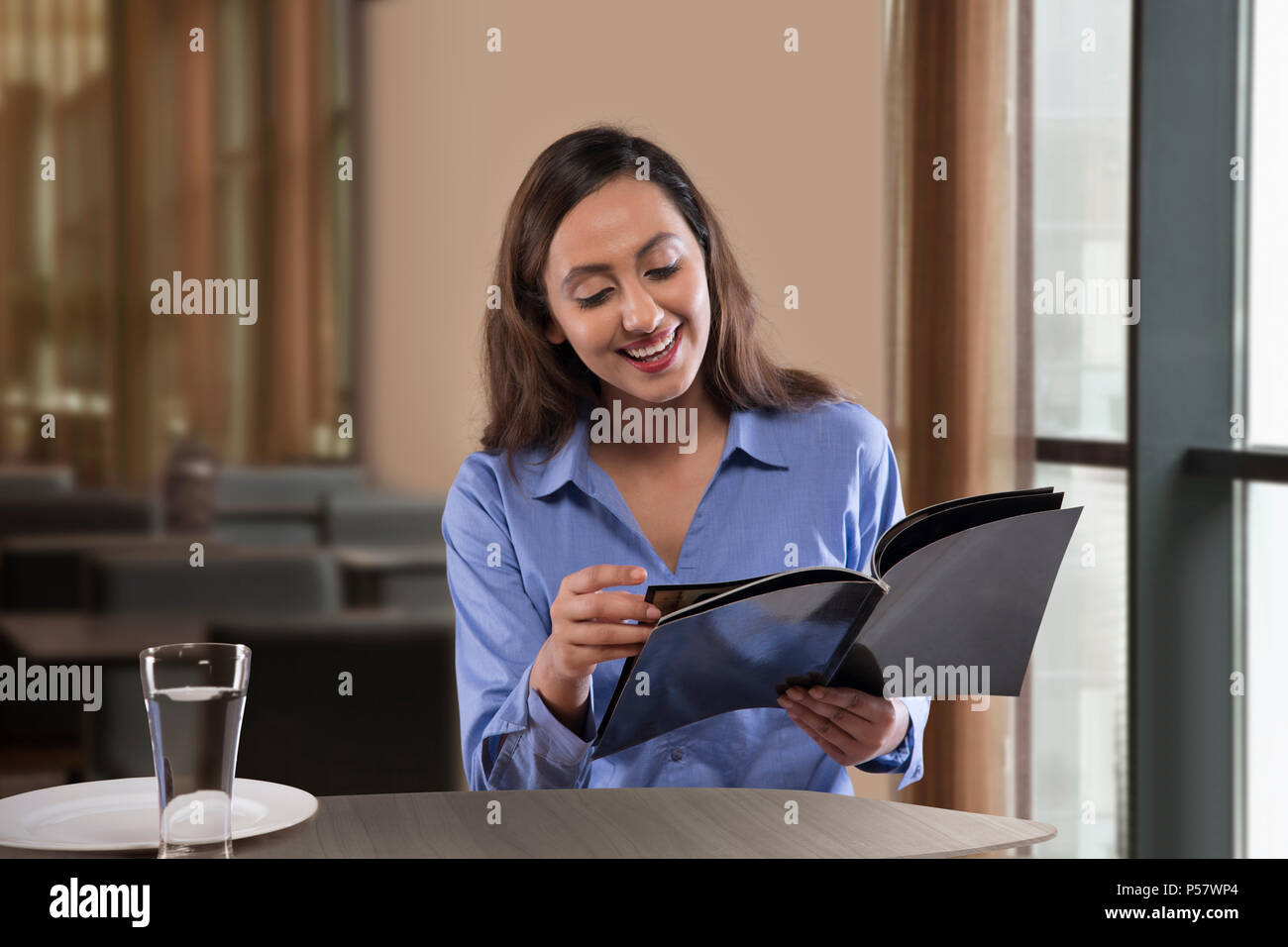 Businesswoman reading magazine on table Banque D'Images
