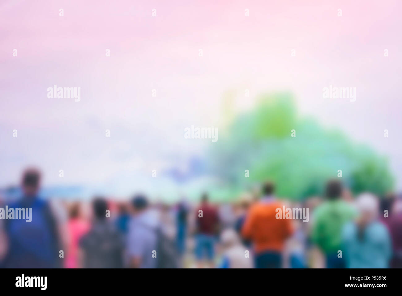 Grande foule de gens méconnaissables retour à nous sur tous, un événement avec la fumée colorée. Arrière-plan flou Banque D'Images