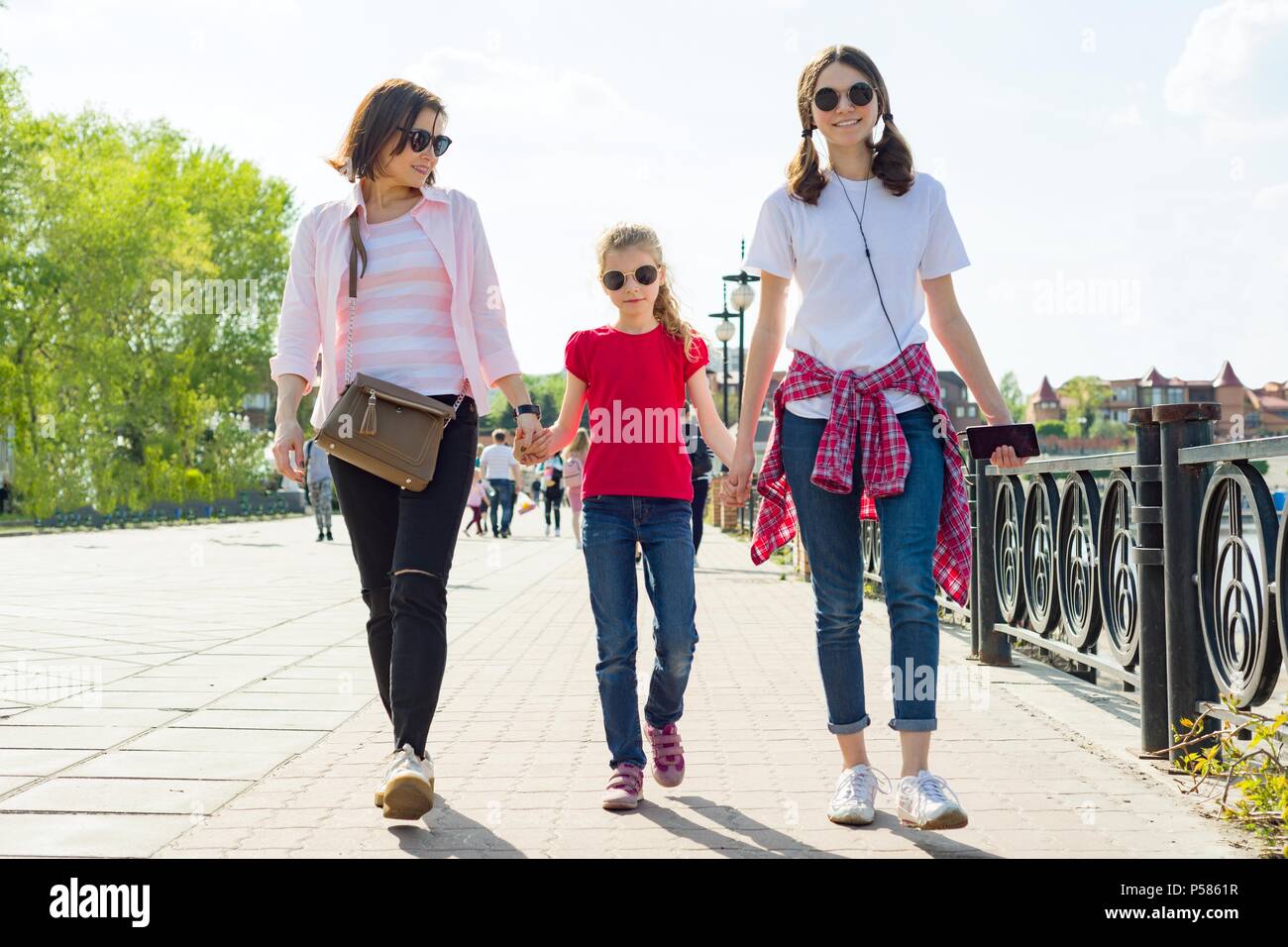 L'extérieur portrait de mère et deux filles. Se tenant la main dans la rue Banque D'Images