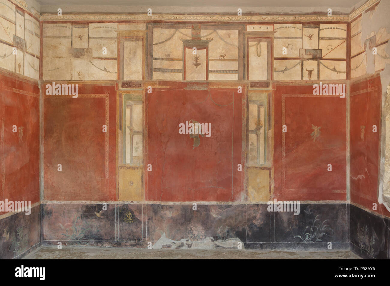 La peinture murale dans le quatrième style avec des panneaux rouges séparés par des éléments architecturaux dans le lavoir de Stephanus (Fullonica di Stephanus) dans le site archéologique de Pompéi (Pompei) près de Naples, Campanie, Italie. Banque D'Images