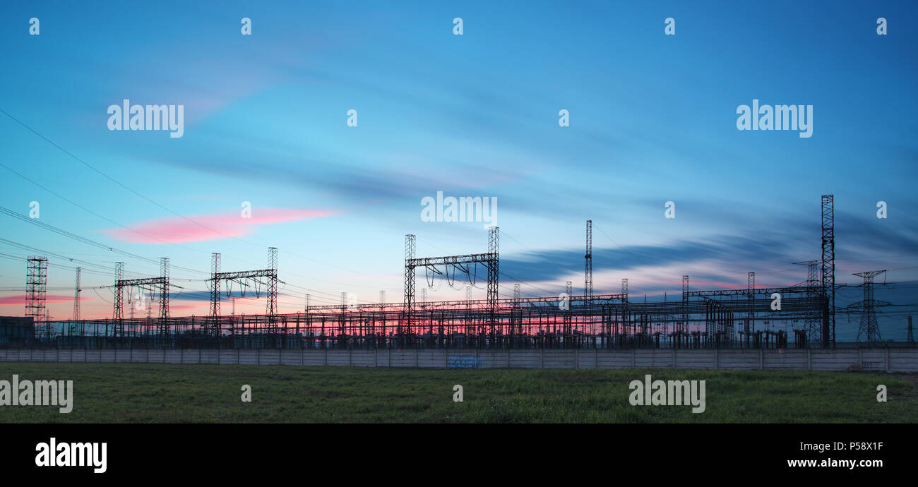 Pylône de transport d'électricité silhouetté contre le ciel bleu au crépuscule Banque D'Images