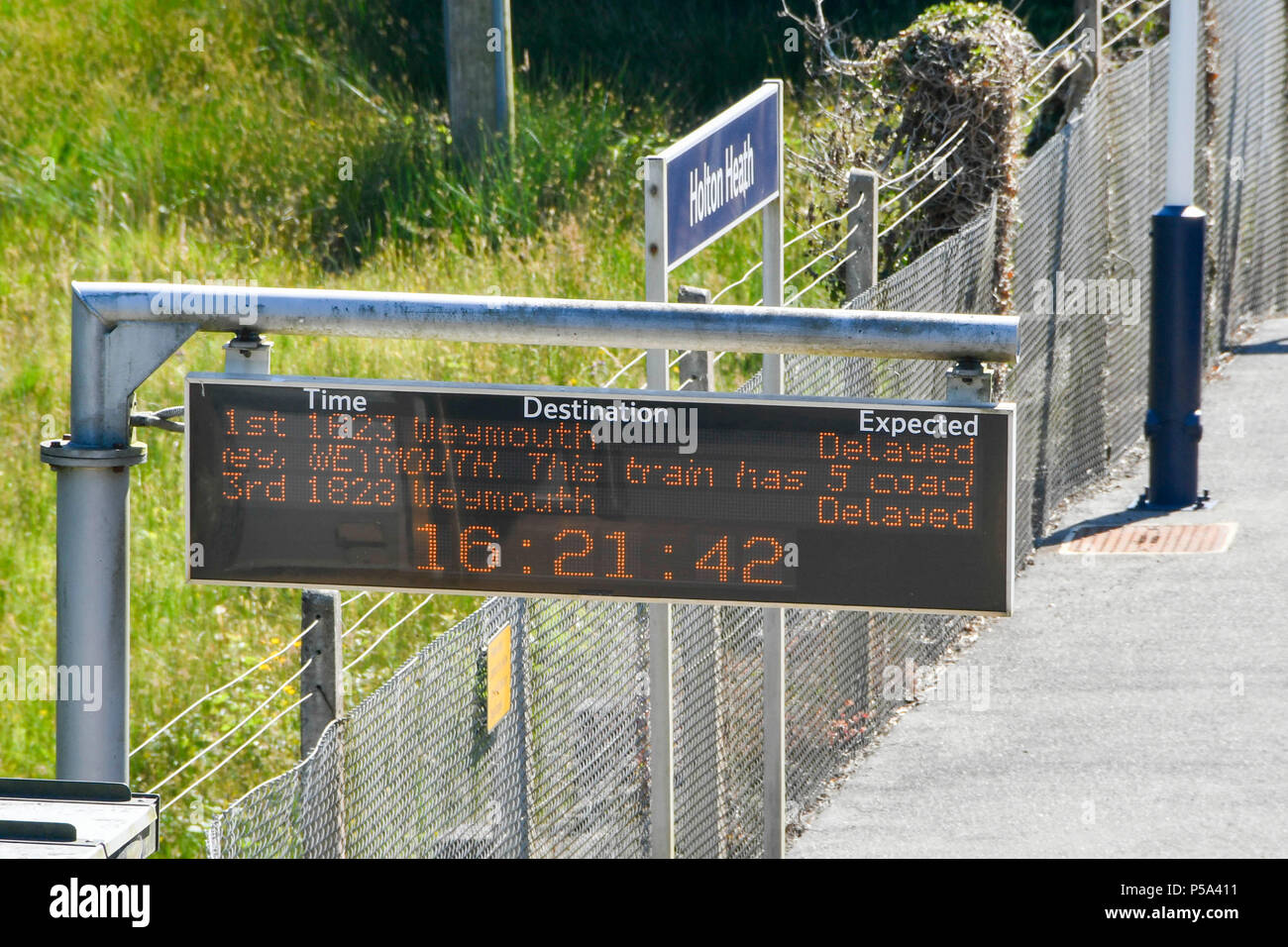 Holton Heath, Dorset, UK. 26 juin 2018. Météo britannique. Signe d'information de la station la station à Holton Heath montrant des retards sur la ligne de chemin de fer de l'ouest du sud dans le Dorset après un petit feu dans un train entre Surbiton et Weybridge a bloqué la ligne. Cet incident est en haut de la limitations de vitesse sur les chemins de fer en raison du risque de flambement des lignes en raison de la température chaude de la vague de chaleur actuelle. Crédit photo : Graham Hunt/Alamy Live News Banque D'Images