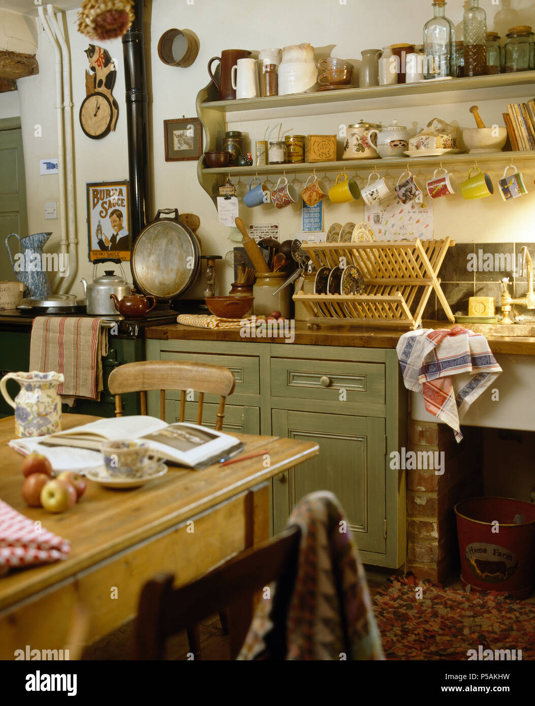 Table et chaises en bois dans la cuisine à l'ancienne unité vert pastel avec à côté d'Aga Banque D'Images