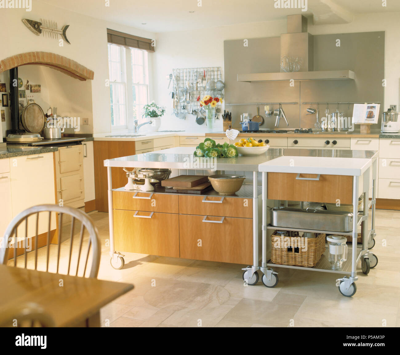 L'île de Grande unité mobile sur roulettes en blanc moderne cuisine avec carreaux de sol calcaire Banque D'Images