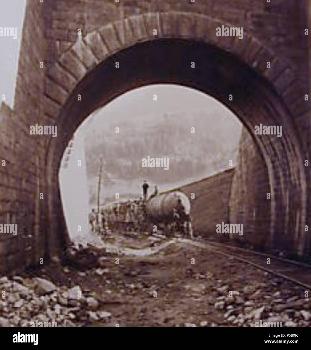N/A. Anglais : l'image montre une locomotive pneumatique utilisé lors de la construction de tunnel ferroviaire du Saint-Gothard derrière une arche ou tunnel court de seulement quelques mètres. La légende originale de l'image se traduit par 'Entrée du Tunnel à Airolo", ce qui indique probablement l'emplacement approximatif de l'écran montré, ce qui n'est pas le sud du portail du tunnel ferroviaire du Saint-Gothard lui-même. La locomotive pneumatique montre l'énergie stockée sous la forme d'air comprimé dans le grand récipient sous pression à l'avant. L'expansion de parution a été utilisé de l'air pour faire fonctionner le moteur de la locomotive. Compresseurs de vapeur w Banque D'Images