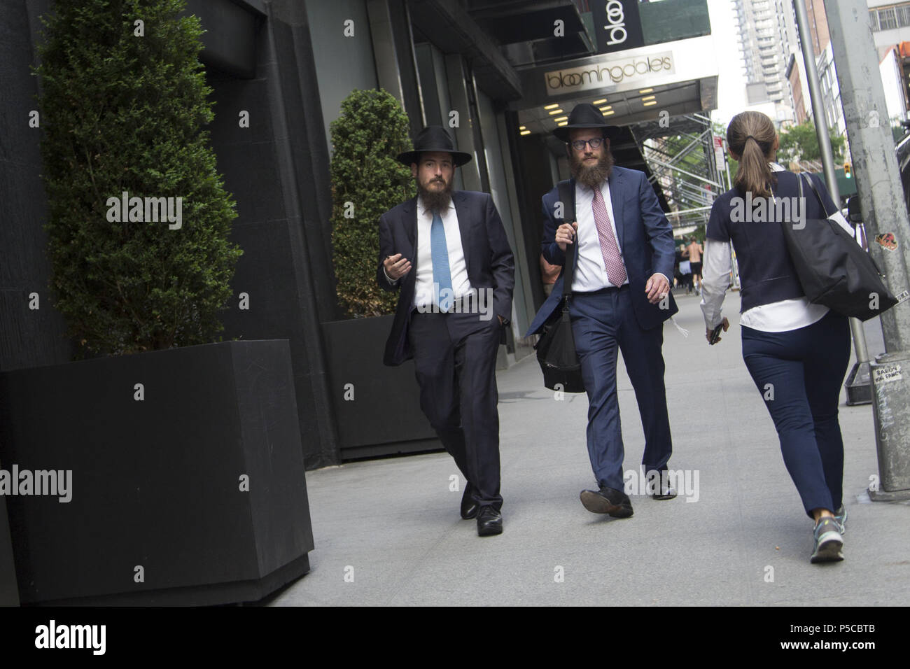 Deux hommes d'affaires juifs marcher sur la 59e Rue par Bloomingdale's à Manhattan. Banque D'Images