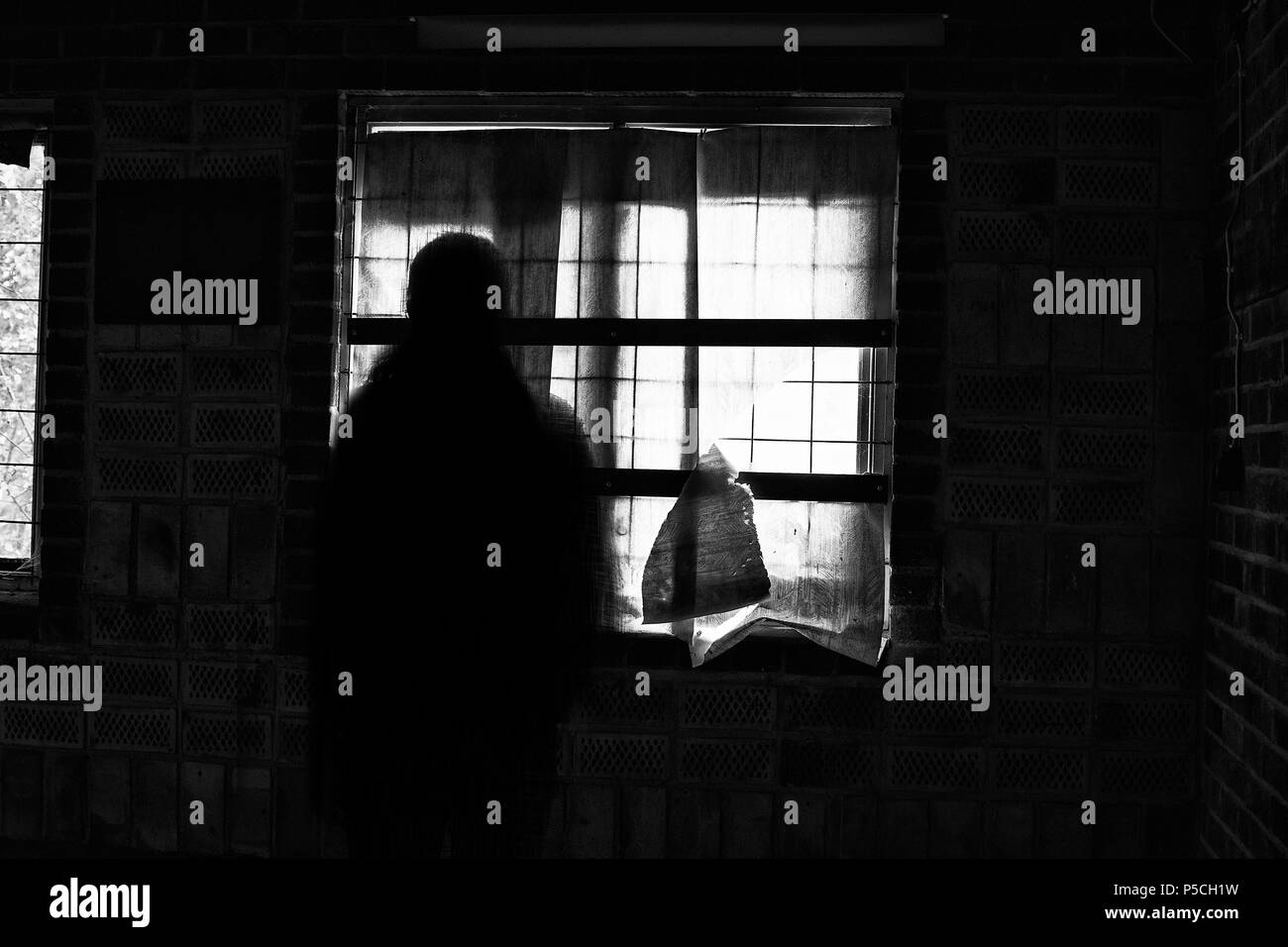 L'ombre de Ghost par la fenêtre dans une maison abandonnée. Banque D'Images