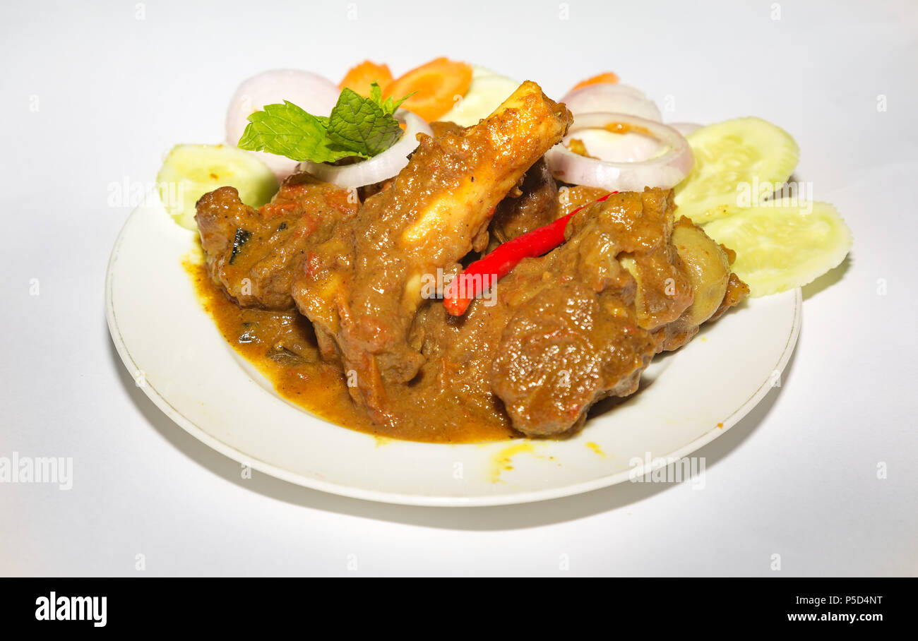 Repas indien populaire de mouton sauce épicée populairement connu comme le mouton kosha avec piment et légumes tranchés. Banque D'Images