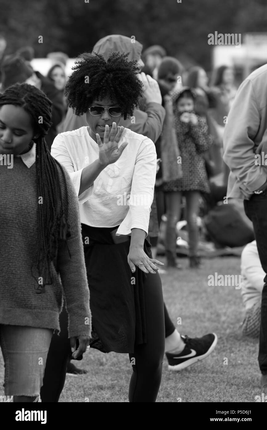 L'image monochrome candide d'une belle noire avec des cheveux bouclés à danser à l'Afrique 2018 Oye music festival à Sefton Park, Liverpool. Banque D'Images