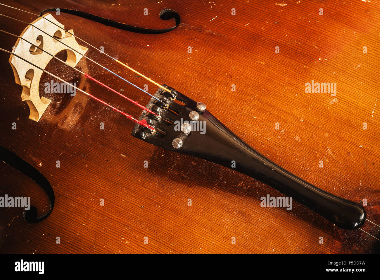 Détails d'un vieux violoncelle poussiéreux, vue rapprochée sur les cordes et le corps. Banque D'Images