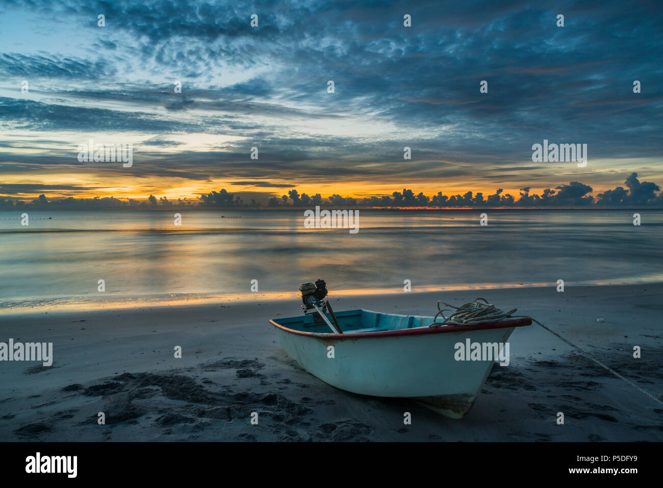 A l'aube avec un bateau sur la plage. Banque D'Images