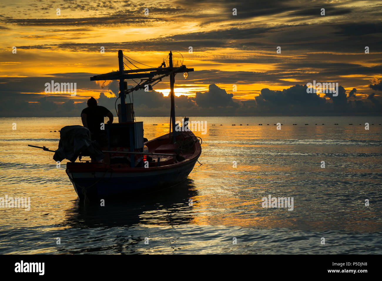 Un bateau de pêcheur dans l'aube prête à travailler. Banque D'Images