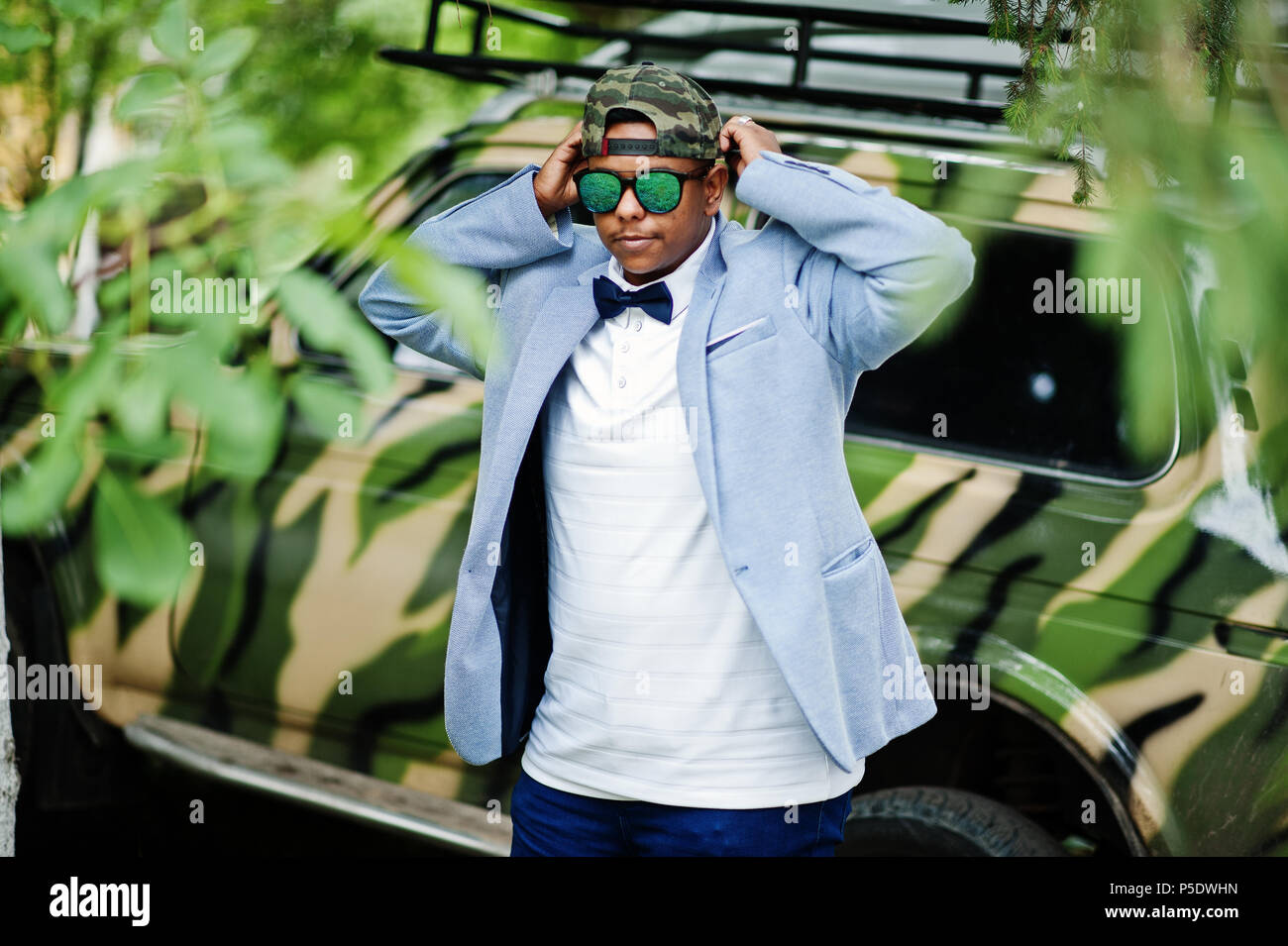 L'homme arabe élégant à lunettes de soleil, chapeau et noeud papillon posé  contre voiture militaire. Modèle garçon arabe Photo Stock - Alamy