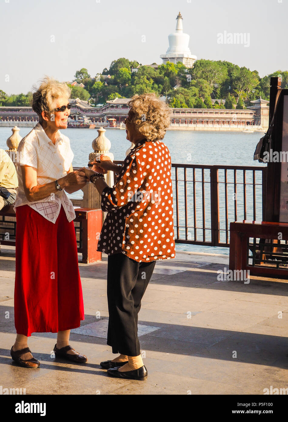 Beijing, Chine - Septembre 2017 : deux femmes âgées de la danse en couple dans les pavillons dans le parc Beihai pendant le coucher du soleil Banque D'Images