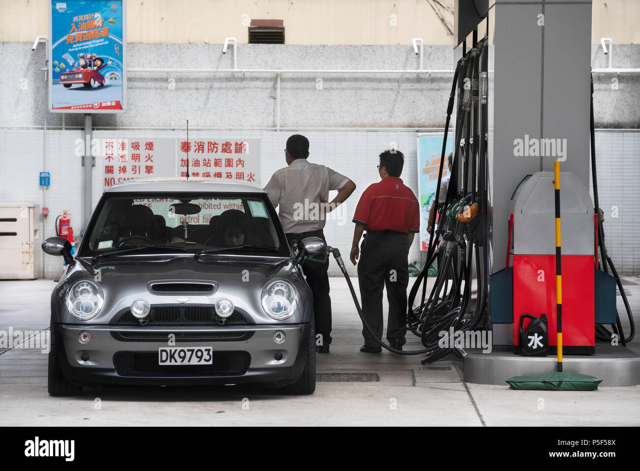 Préposé de station Caltex gaz pompes dans une station-service dans la région de Sham Shui Po, Hong Kong. Banque D'Images