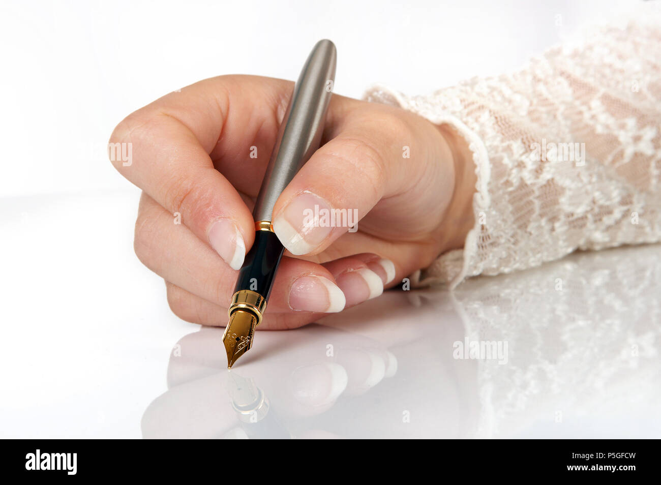 La main élégante écrit avec un stylo à plume d'or Banque D'Images