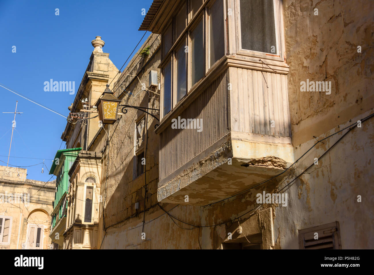 Un balcon en bois sur des maisons traditionnelles dans les ruelles de la vieille ville de Victoria, Gozo, Malte. Banque D'Images